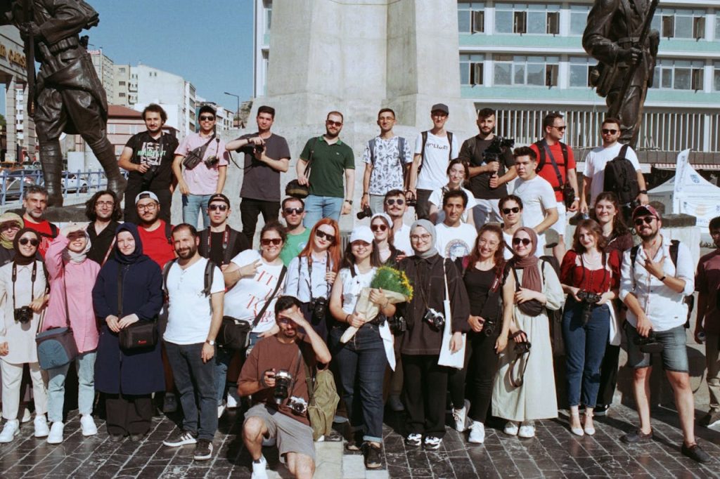 A large group of tourists gathered at a city square in front of statues, perfect for travel-themed projects.